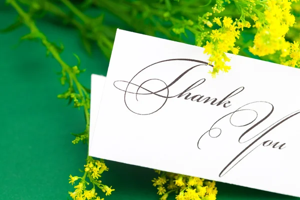Yellow field flower and card signed thank you on green backgro — Stock Photo, Image