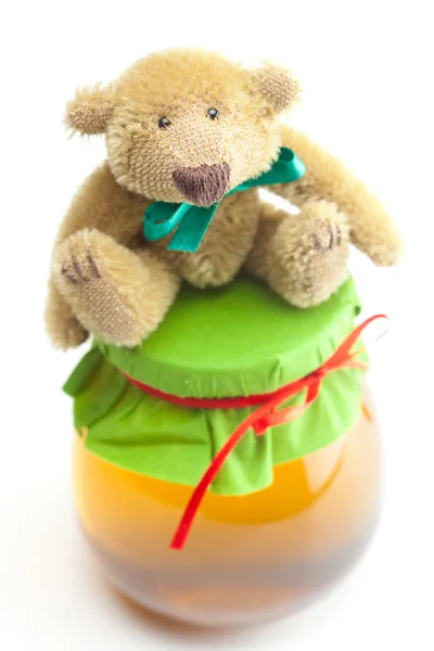 Teddy bear and jar of honey isolated on white — Stock Photo, Image