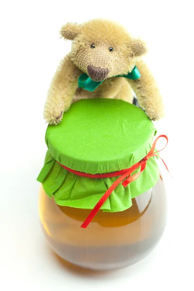Ursinho de pelúcia e frasco de mel isolado em branco — Fotografia de Stock
