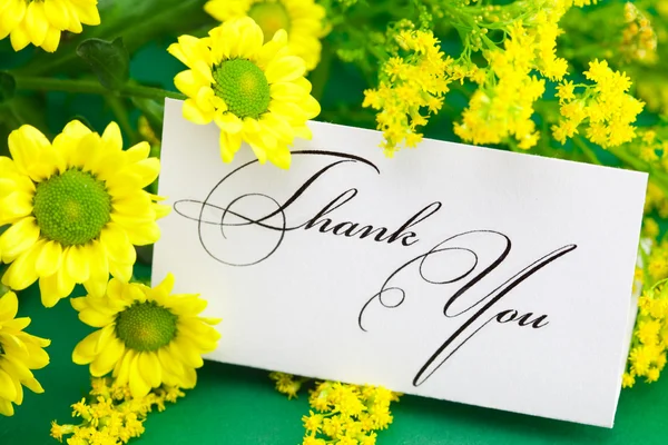 Gele daisy en kaart ondertekend dank u op groene achtergrond — Stockfoto