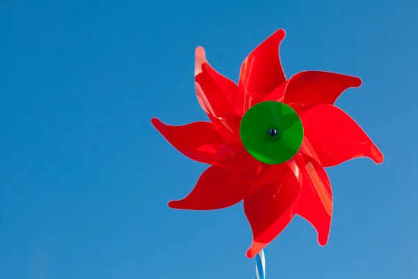 Brinquedo moinho de vento vermelho contra o céu azul — Fotografia de Stock