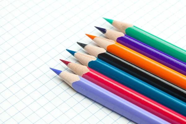 Caderno xadrez com um lápis em espiral e colorido — Fotografia de Stock