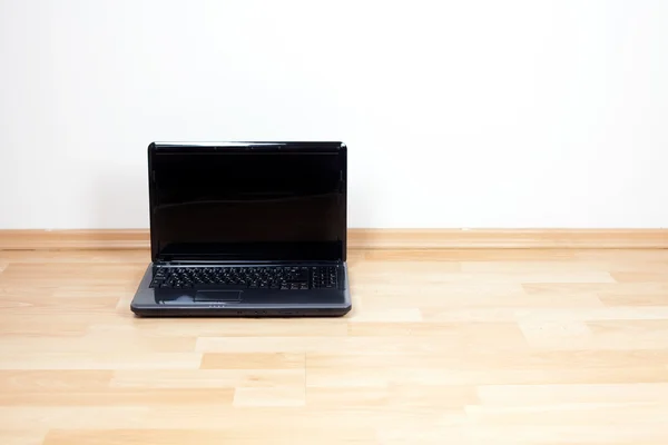 Laptop stands on the floor in the room