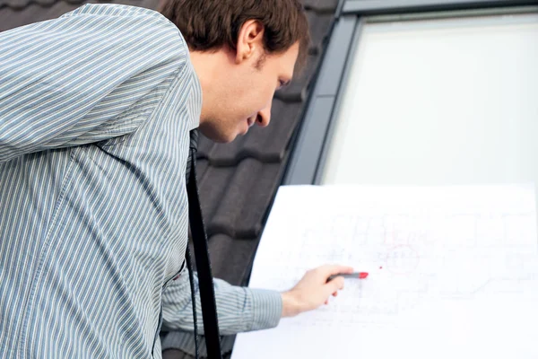 Young man architect presenting a project against the background — Stock Photo, Image