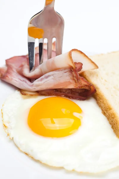 皿、フォーク、w 上に分離されてパン揚げ卵とベーコン — ストック写真