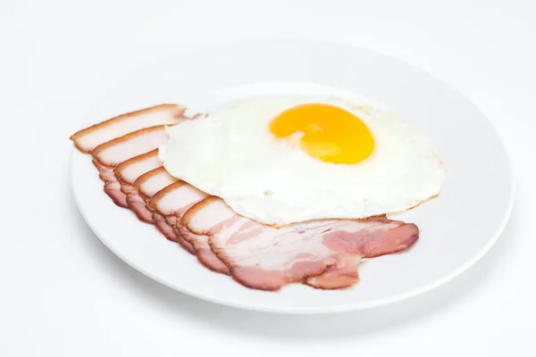 Pancetta e uova fritte su un piatto isolato su bianco — Foto Stock