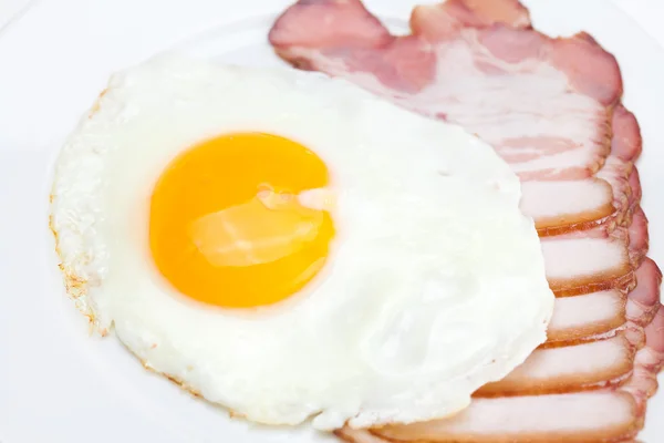 Tocino y huevos fritos en un plato aislado en blanco —  Fotos de Stock