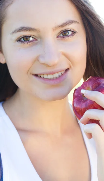 Portrait of a beautiful young woman with apple outdoor — Stock Photo, Image