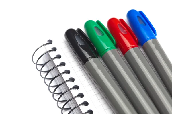 Colored markers and a notebook isolated on white Stock Photo