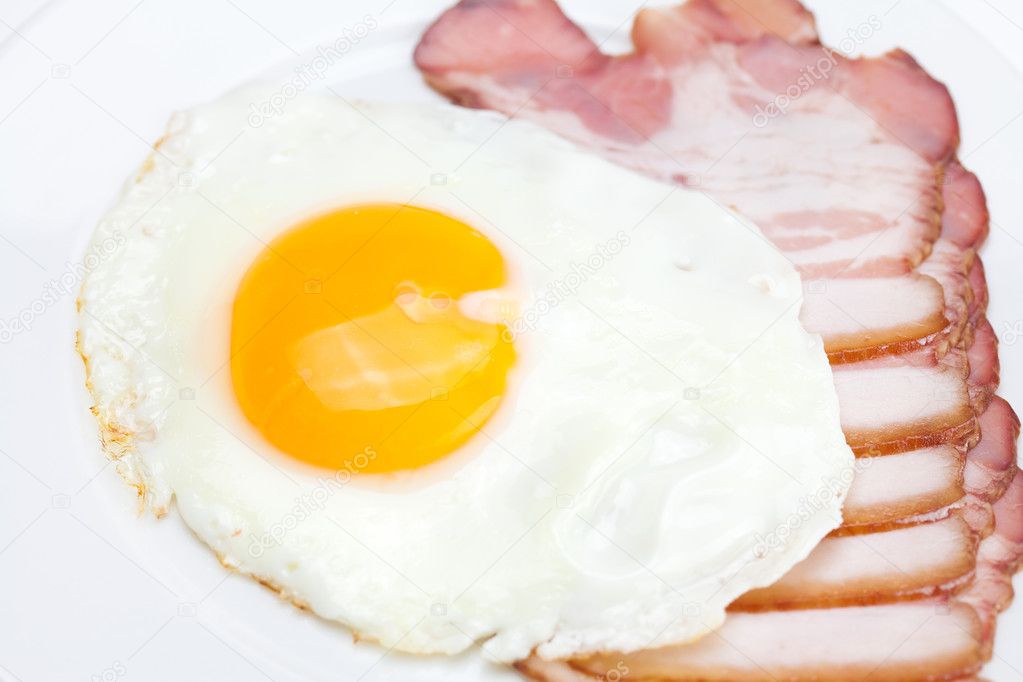 Bacon and fried eggs on a plate isolated on white