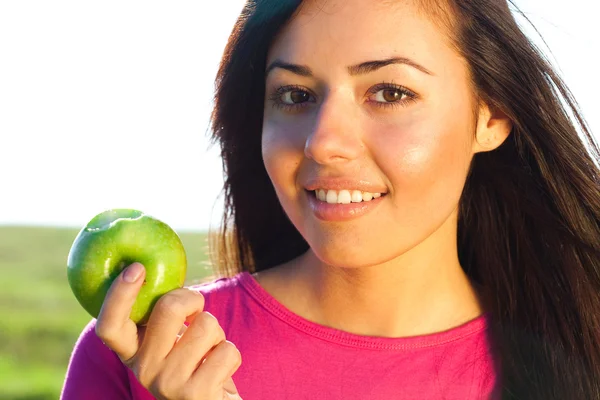 Porträt einer schönen jungen Frau mit Apfel im Freien — Stockfoto
