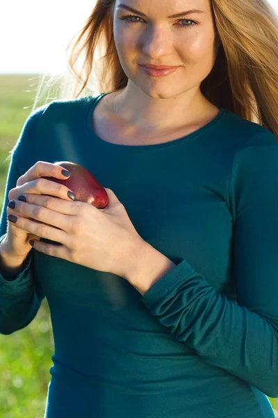 Porträtt av en vacker ung kvinna med apple utomhus — Stockfoto