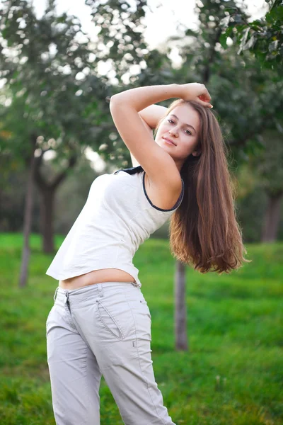 Yeşil çimenlerin üzerinde duran güzel genç kadın — Stok fotoğraf