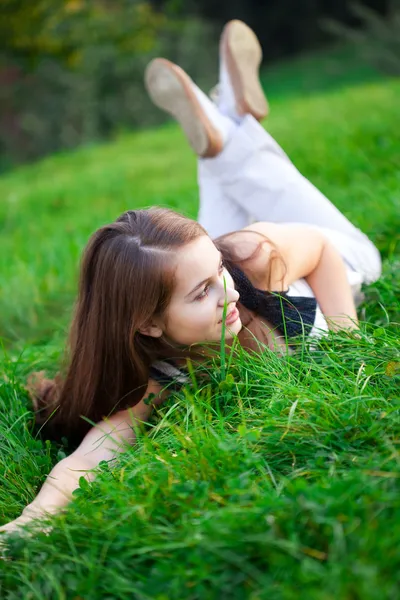Piękna młoda kobieta, leżąc na zielonej trawie — Zdjęcie stockowe