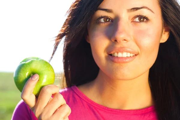 Ritratto di una bella giovane donna con mela all'aperto — Foto Stock