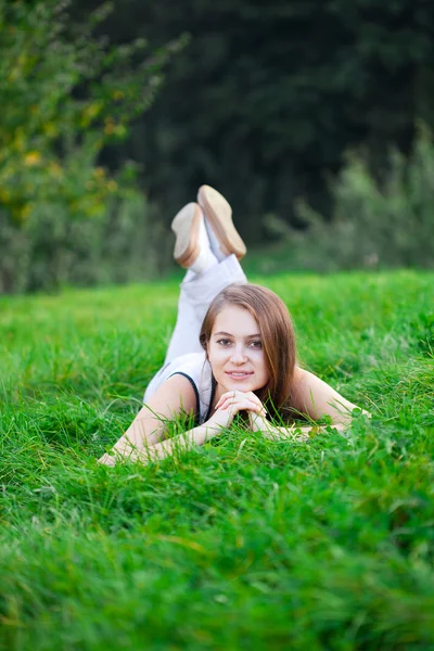 Krásná mladá žena leží na zelené trávě — Stock fotografie