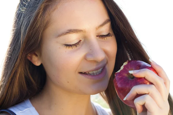 Retrato de una bella mujer joven con manzana al aire libre — Stockfoto