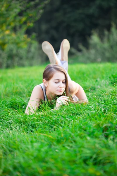 Gyönyörű fiatal nő feküdt a zöld fű — Stock Fotó