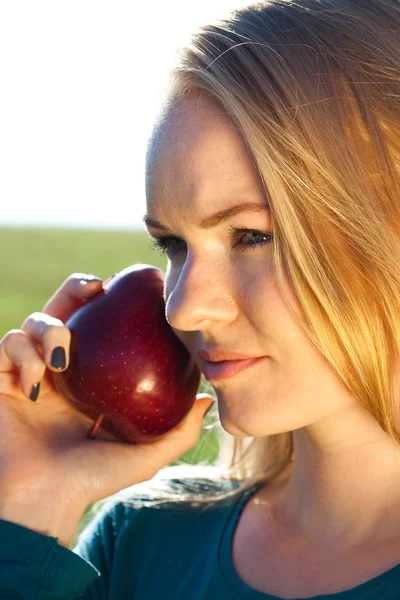 Retrato de uma bela jovem com maçã ao ar livre — Fotografia de Stock