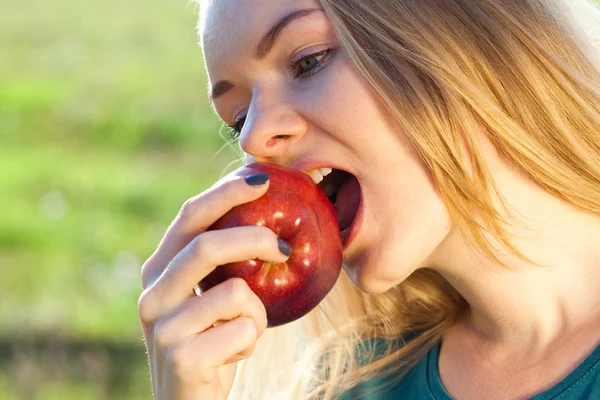 Retrato de uma bela jovem com maçã ao ar livre — Fotografia de Stock