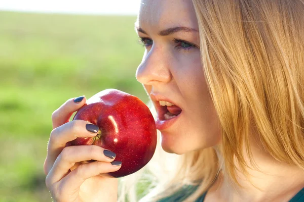 Portrait d'une belle jeune femme avec pomme en plein air — Photo