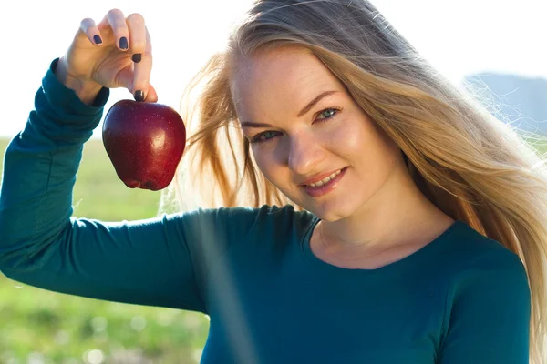 Porträtt av en vacker ung kvinna med apple utomhus — Stockfoto