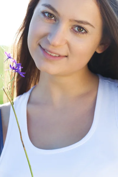 Ritratto di una bella giovane donna con fiore all'aperto — Foto Stock