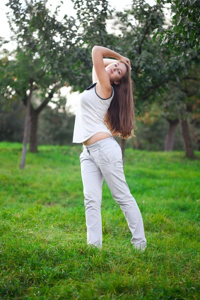 Hermosa mujer joven de pie sobre hierba verde — Foto de Stock