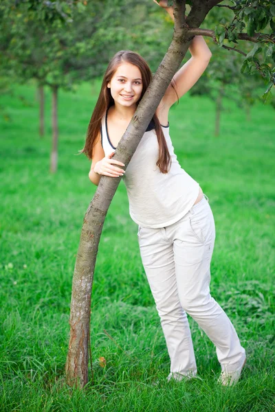 Yeşil çimenlerin üzerinde duran güzel genç kadın — Stok fotoğraf