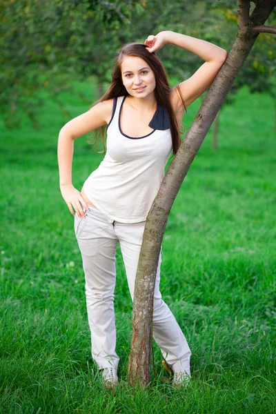 สาวสวยยืนบนหญ้าสีเขียว — ภาพถ่ายสต็อก