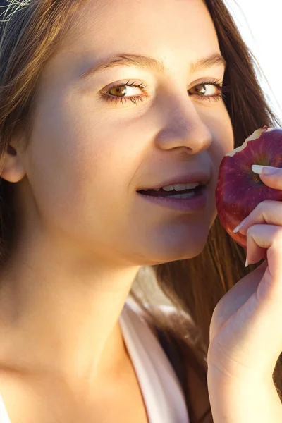 Retrato de una hermosa joven con manzana al aire libre — Foto de Stock
