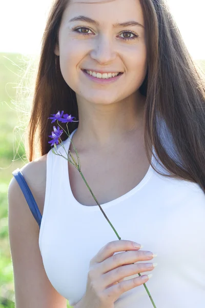 Retrato de una hermosa joven con flor al aire libre — Foto de Stock