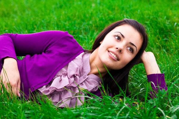 Красивая молодая женщина лежит на зеленой траве — стоковое фото
