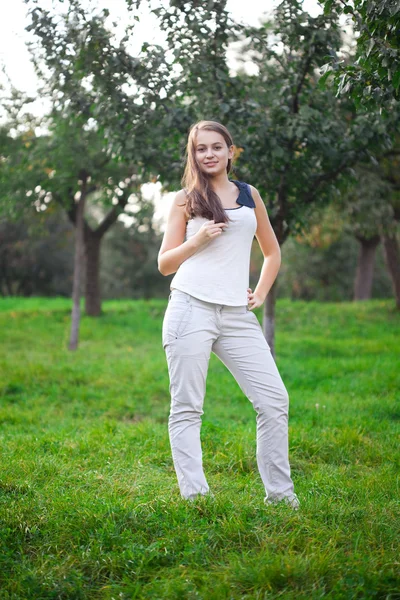 Piękna młoda kobieta stojąc na zielonej trawie — Zdjęcie stockowe