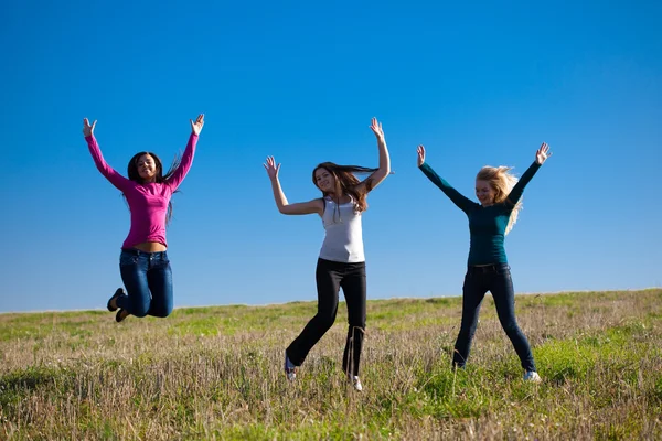 Trzech młodych piękna kobieta skoki w polu przed s — Zdjęcie stockowe