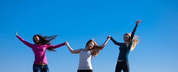 Trois jeunes belles femmes sautant dans le champ contre le s — Photo