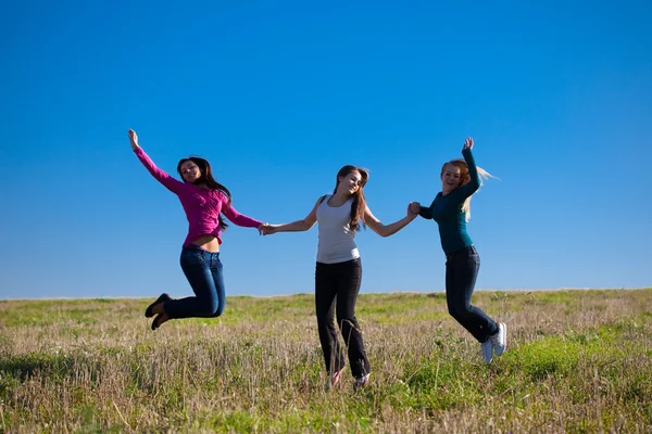 三个年轻漂亮的女人跳进反对 s 字段 — 图库照片
