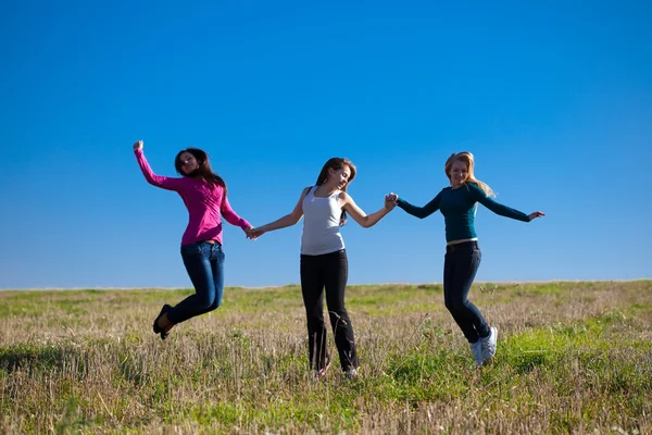Üç genç güzel kadın s karşı alan içine atlama — Stok fotoğraf