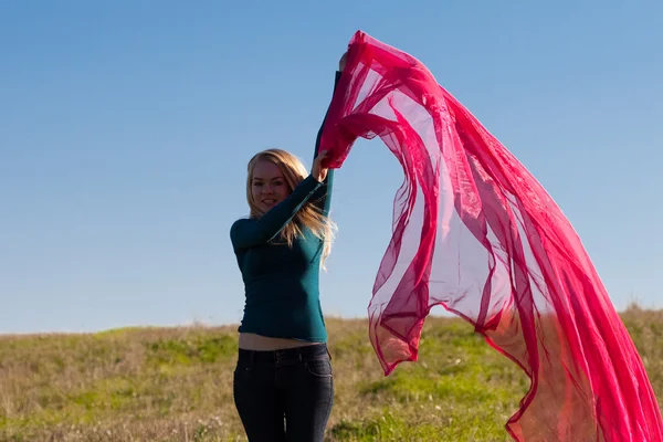 Jovem bela mulher pulando com tecido para o campo contra — Fotografia de Stock