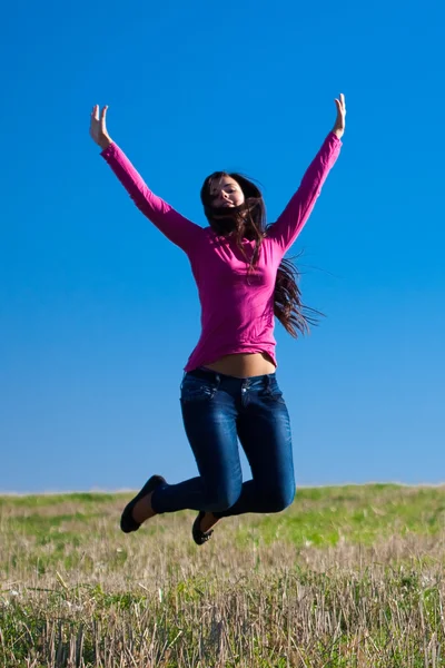 Fiatal gyönyörű nő ellen az égen jumping — Stock Fotó