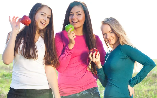 Portret trzech młodych piękna kobieta z jabłkiem na ba niebo — Zdjęcie stockowe