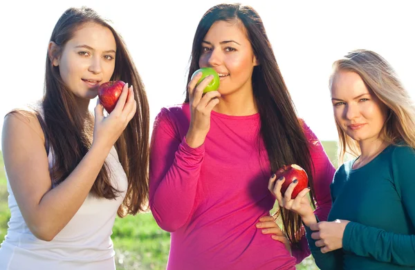 Retrato de três jovem mulher bonita com maçã no céu ba — Fotografia de Stock