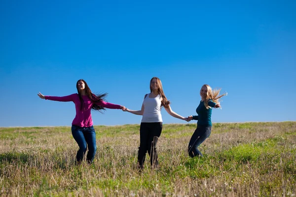 Trzech młodych piękna kobieta skoki w polu przed s — Zdjęcie stockowe
