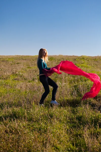 Young beautiful woman jumping with tissue into the field against — Stock Photo, Image