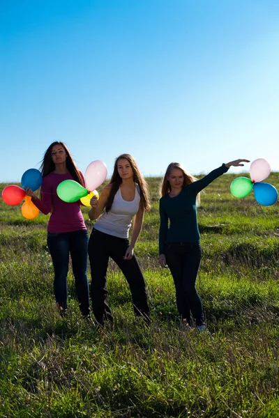 Τρεις νέοι όμορφη γυναίκα με μπαλόνια για το πεδίο κατά — Φωτογραφία Αρχείου