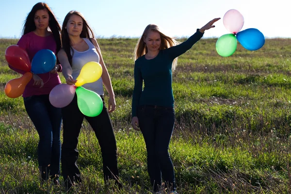 Τρεις νέοι όμορφη γυναίκα με μπαλόνια για το πεδίο κατά — Φωτογραφία Αρχείου