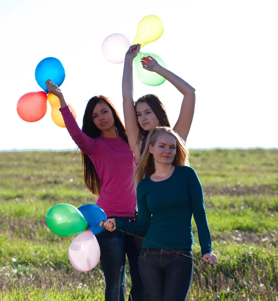 Trois jeunes belle femme avec des ballons dans le champ contre — Photo