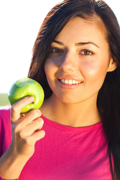 Portrait of a beautiful young woman with apple outdoor Stock Photo