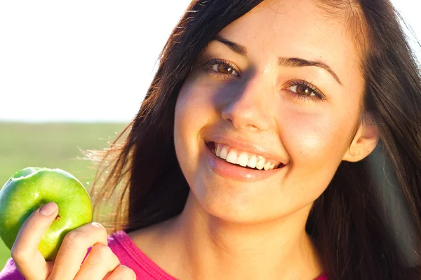 Portrait of a beautiful young woman with apple outdoor Royalty Free Stock Images