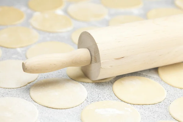 Forme ronde de la pâte et rouleau à pâtisserie avec de la farine sur la table — Photo